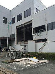 熊本地震で被害を受けた建物の外壁崩落とがれきの写真